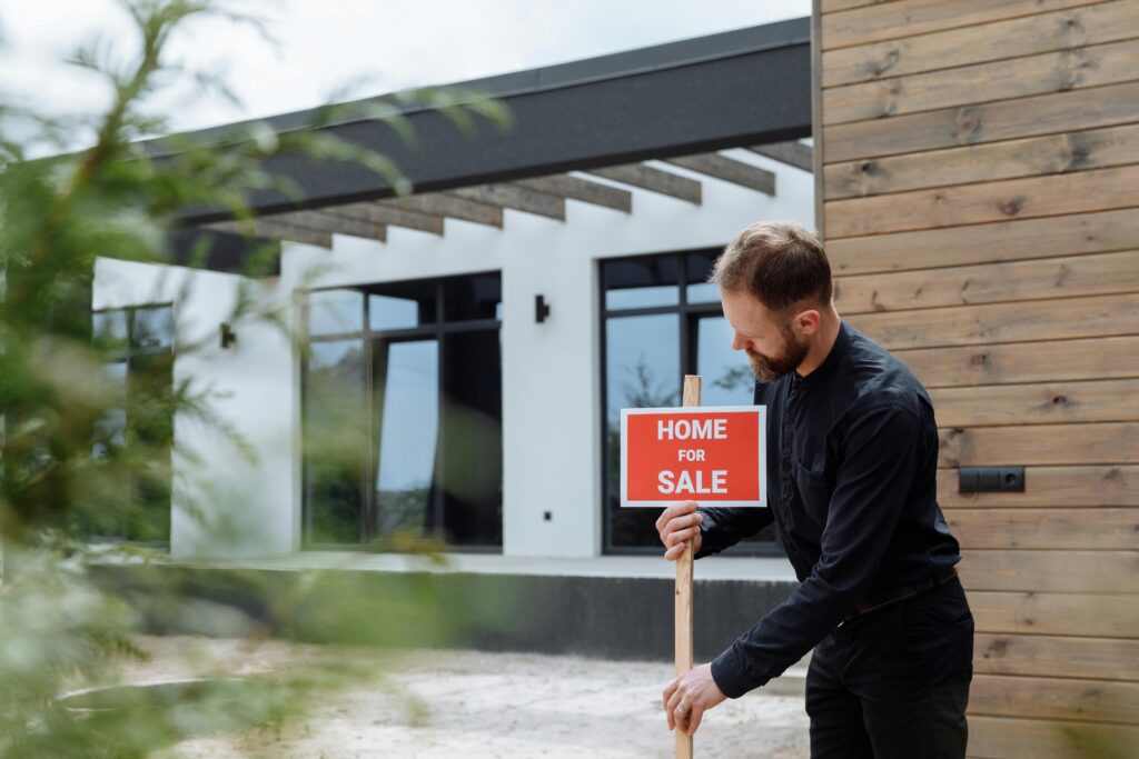 Man with for sale sign getting mortgage in Calgary